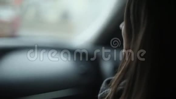 一个漂亮的年轻女人说话的侧视布鲁内特女孩坐在车上视频的预览图