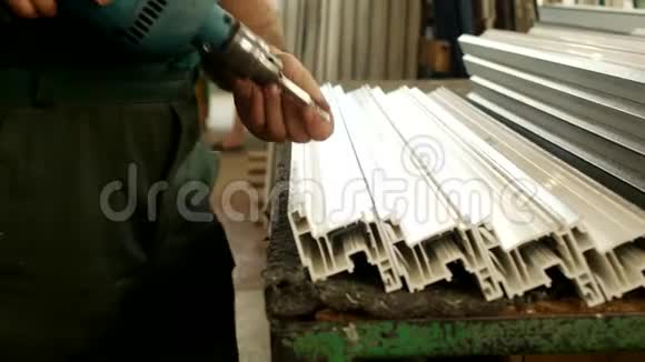 生产pvc窗时工人将金属型材固定在pvc窗段的塑料型材上视频的预览图