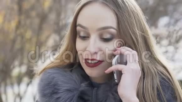 在冬季大街上打电话的漂亮女孩慢慢地视频的预览图