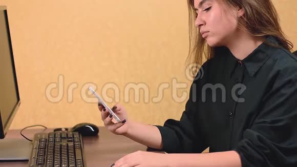 年轻的女商人在办公室里用智能手机视频的预览图