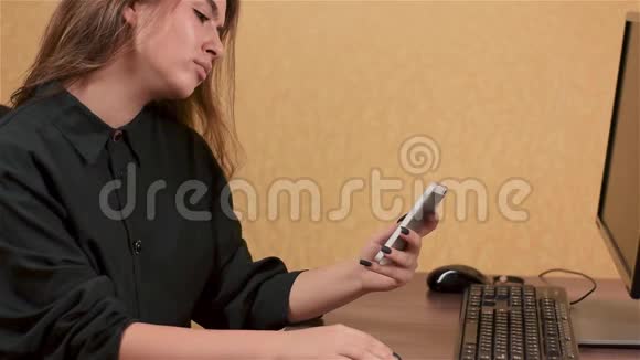 女商人在办公室里用智能手机视频的预览图