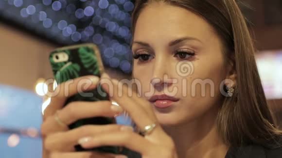 年轻女子在咖啡厅使用智能手机视频的预览图