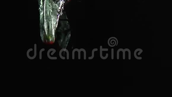 智利辣椒落入水中在黑色背景下拍摄视频的预览图