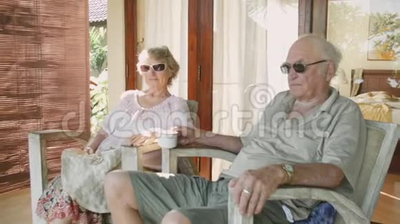 一对戴墨镜的老人坐在自家前院视频的预览图
