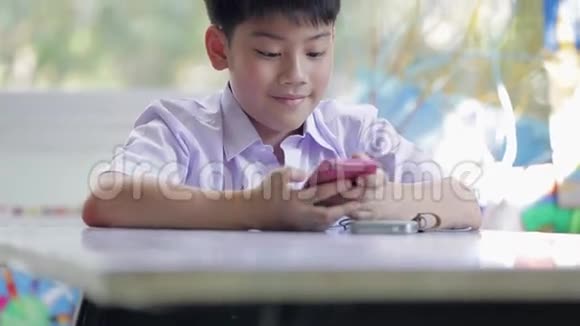 快乐的亚洲孩子用手机和妈妈通话视频的预览图