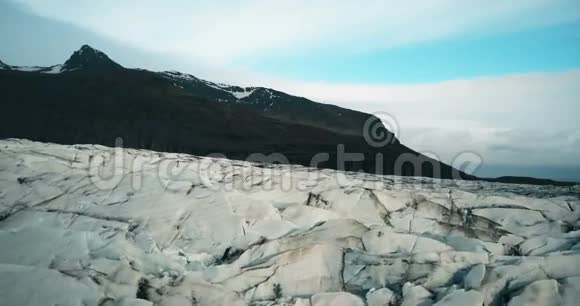 用黑色火山灰空中拍摄冰缝在冰岛瓦特纳冰盖上飞行的直升机视频的预览图