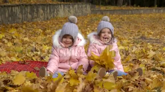 两个女孩穿着衣服戴着帽子的姐妹坐在黄色的le上视频的预览图