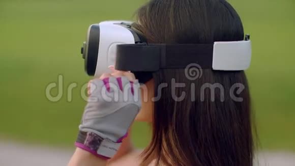 在公园里使用虚拟现实耳机的女人戴着VR眼镜的亚洲女人视频的预览图