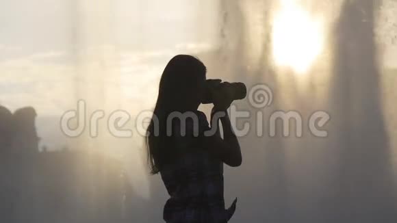 日落喷泉附近的女摄影师视频的预览图