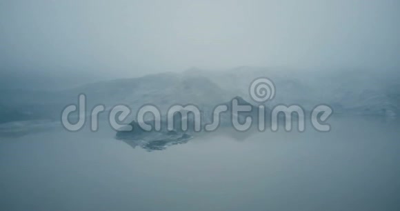 冰岛冰川Myrdalsjokull的鸟瞰图直升机飞越融化的冰山在雾谷在湖里视频的预览图
