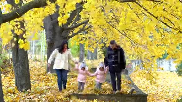 秋天幸福的一家人沿着公园的小巷散步帕雷视频的预览图