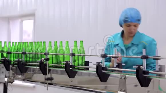 线的制水该员工将玻璃瓶放置在自动清洗和灌装瓶子的生产线上视频的预览图