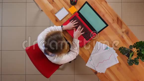 一位年轻的高加索女商人用笔记本电脑在办公室里的办公桌上进行特写镜头视频的预览图