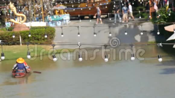 人们正在棕色的河流上的一艘船上游泳去泰国在后台行走的人身上有一个白色的花环视频的预览图