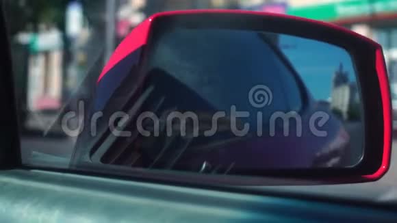 一辆红色汽车后视镜中的路景视频的预览图