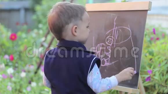 小孩用粉笔画在黑板上视频的预览图