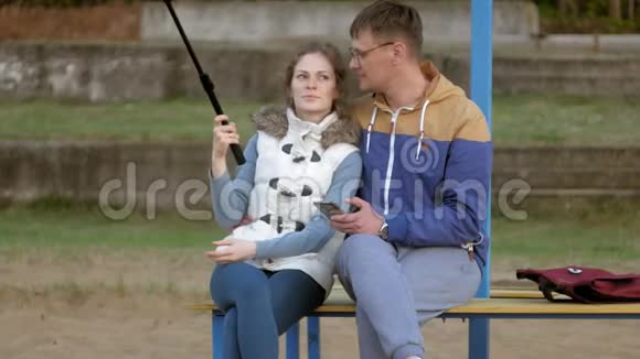 男fnd女微笑公园用智能手机自拍视频的预览图
