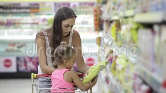 妈妈和小女儿在超市挑选一片雪花视频的预览图