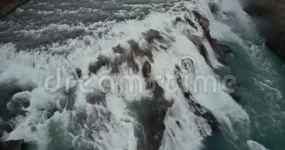 鸟瞰峭壁水流湍急直升机飞过冰岛强大的瀑布视频的预览图