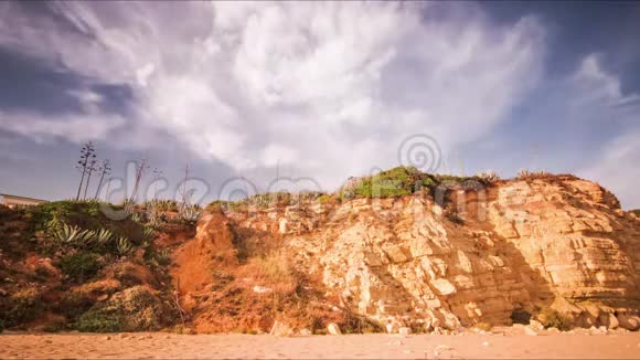 在沙滩上的岩石峭壁上时间流逝的天空蓝天白云视频的预览图