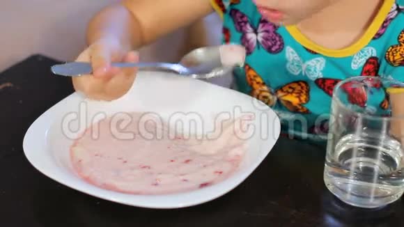 小女孩贪婪地吃着半月粥用水从透明玻璃中洗下来特写镜头视频的预览图