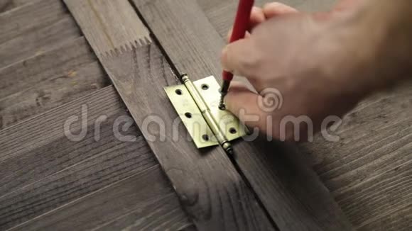 工人正在用螺丝刀把门铰链固定在家具上视频的预览图