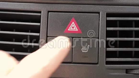 男人的手在汽车仪表盘上按下加热座椅按钮视频的预览图