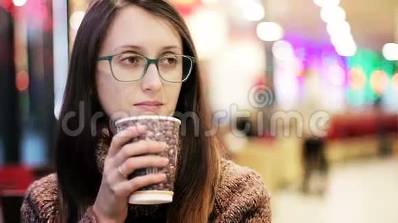 戴眼镜的美女在咖啡馆喝咖啡视频的预览图