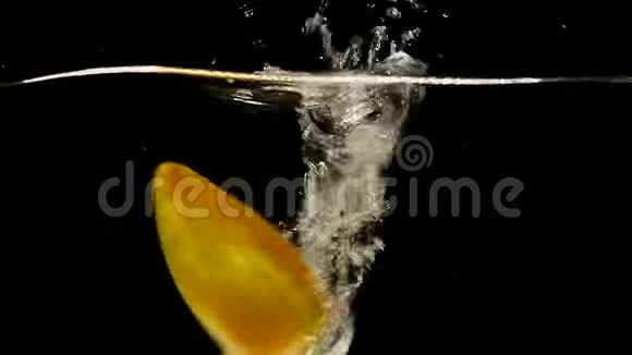 黄色甜椒辣椒蔬菜在黑色背景下掉入水中视频的预览图