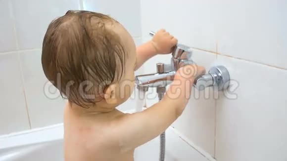 特写4K镜头可爱的幼儿男孩在浴室打开水龙头视频的预览图