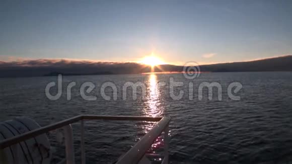 在斯瓦尔巴特的地平线上日落的背景下船在水里视频的预览图