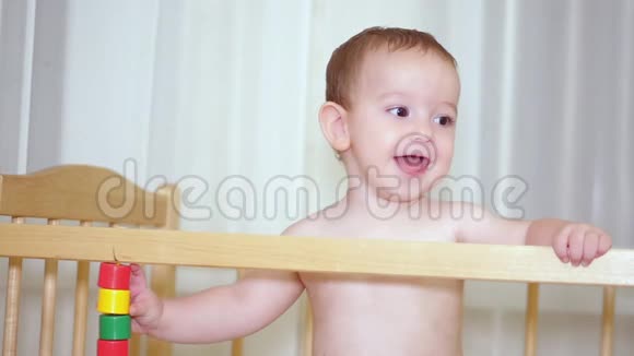 婴儿床上一个迷人的孩子笑着拍手同时试图让她妈妈笑视频的预览图