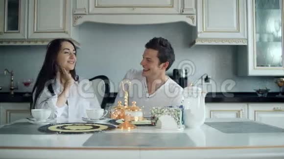 年轻夫妇在家的厨房里一起吃早餐视频的预览图