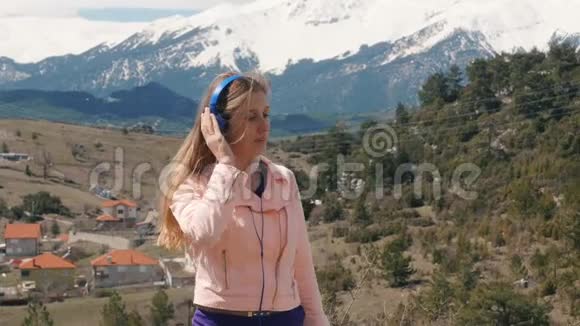 在户外用耳机听音乐的年轻女子视频的预览图