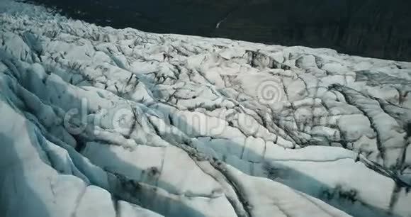 科普特飞过冰岛的冰脊黑色火山灰的白色冰川Vatnajokull的特写鸟瞰图视频的预览图