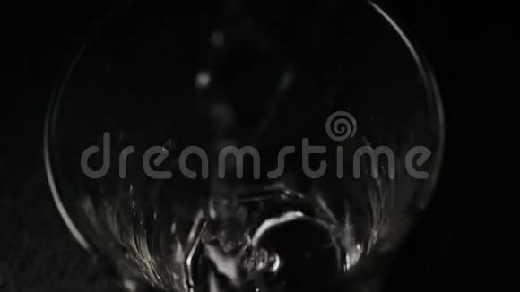 慢动作在黑桌上的玻璃杯里水流视频的预览图