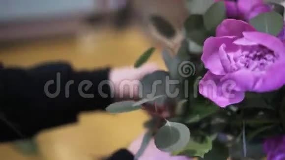 把年轻的花店铺成一束粉红色的花和树枝视频的预览图