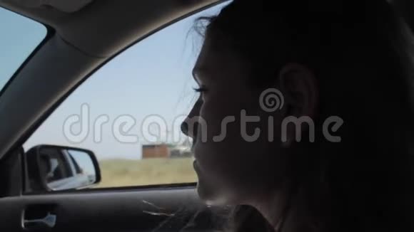 风吹过女孩的剪影和头发在车里视频的预览图