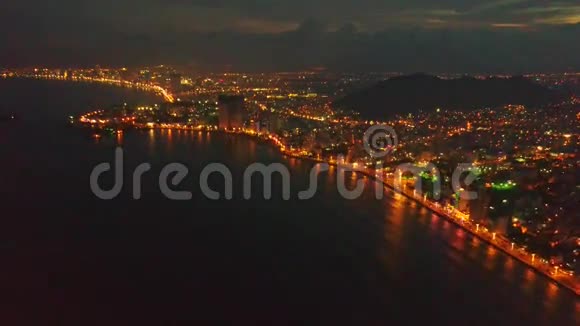 夜晚一个个城市在黑暗的海洋湾上空飞翔视频的预览图
