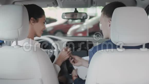 女商人在成功地买了一辆汽车后与一个推销员握手视频的预览图