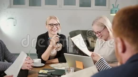 创意商业团队在创业办公室的餐桌上快乐美丽的金发女郎参与了对话视频的预览图
