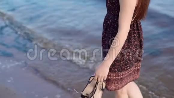 日落时这位黑发女郎沿着沙滩散步视频的预览图