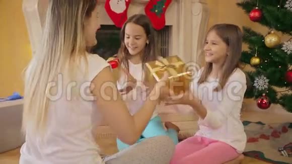 两个女孩在收到圣诞礼物后拥抱母亲的肖像视频的预览图