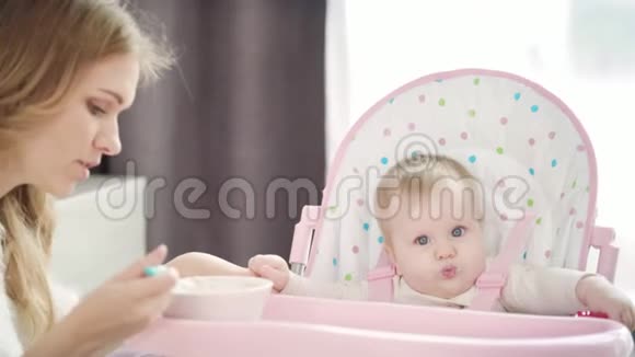 年轻妈妈用勺子喂婴儿母亲喂养儿童视频的预览图