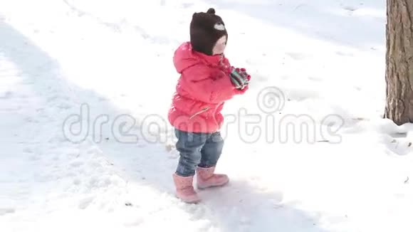 穿红色衣服的小女孩在冬天扔雪的肖像视频的预览图