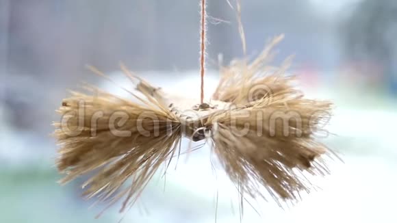 用稻草做翅膀的装饰性木鸟悬挂在窗边背景模糊慢动作1920x1080视频的预览图