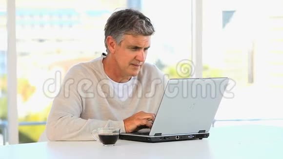 一个在笔记本电脑上工作的业余中年男人视频的预览图
