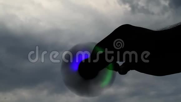 在多云的天空背景下一个人的手在旋转视频的预览图