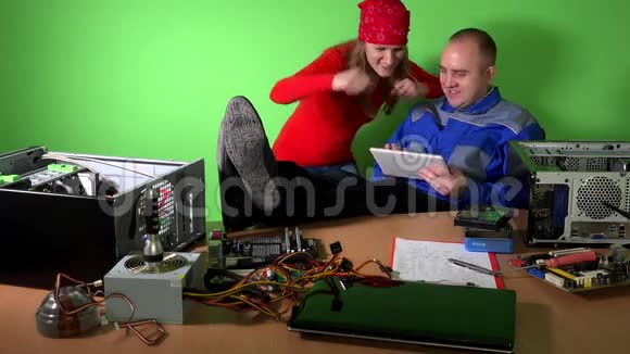 粗心的技师男女在工作中玩平板电脑视频的预览图