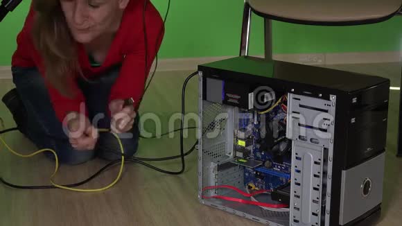 办公室女孩把电缆连接到桌子下面的电脑上女人修理电脑视频的预览图